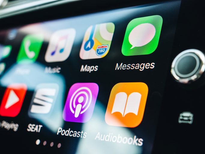 Woman pressing button on the Apple CarPlay